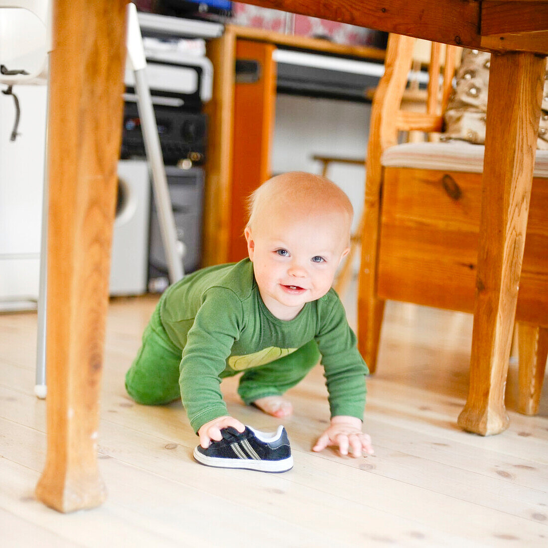 Smiling toddler under table