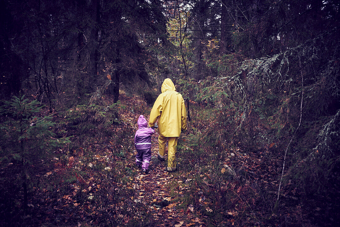 Parent with child walking through forest