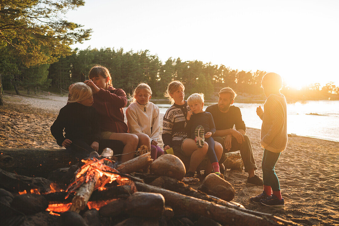 Familie am Lagerfeuer am Strand