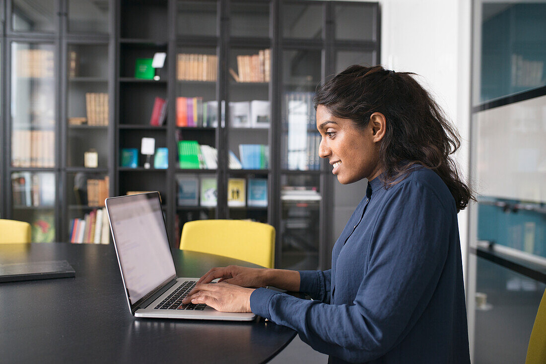 Junge Frau mit Laptop im Büro