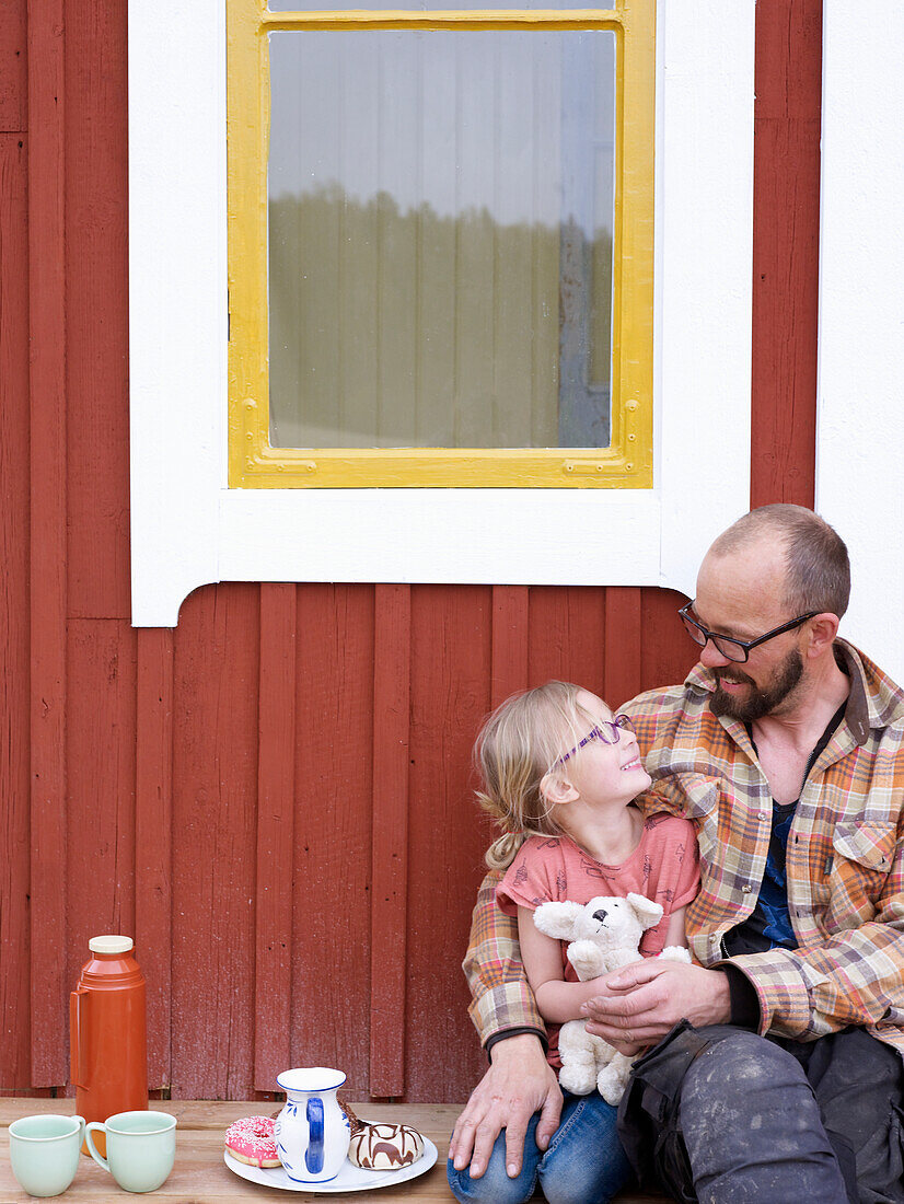 Vater mit Tochter vor einem Haus