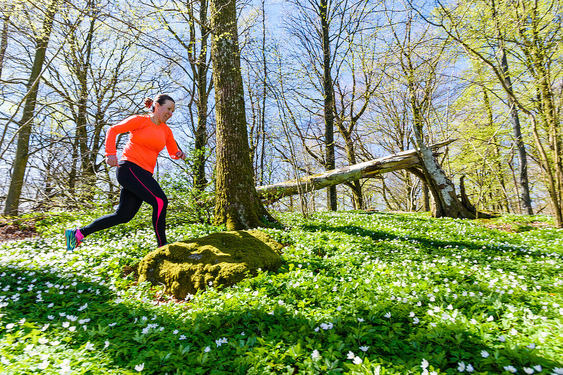 Woman jogging through forest