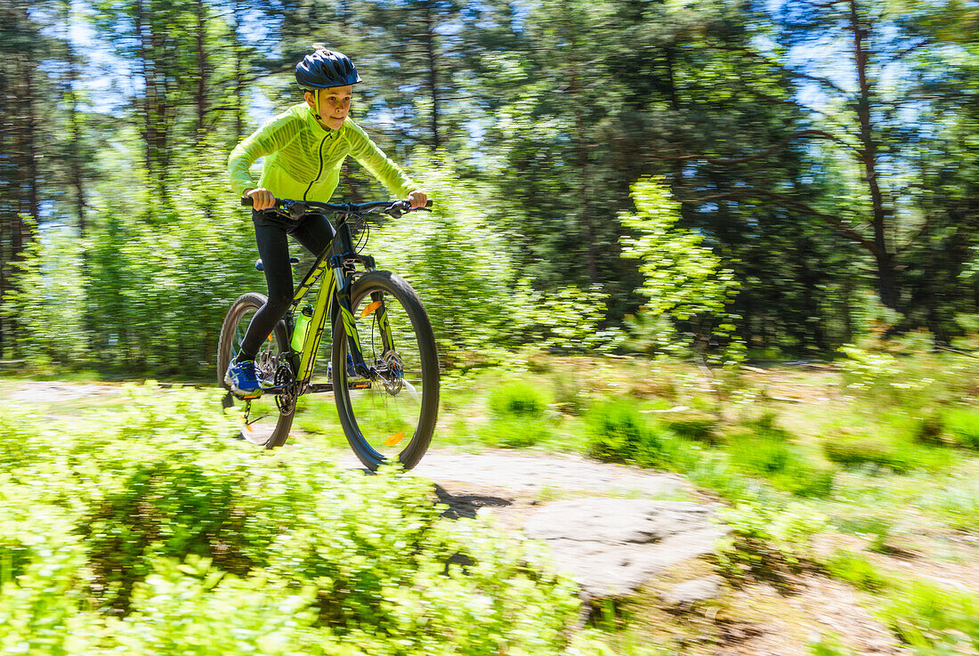 Boy cycling through forest