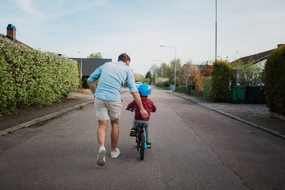 Vater bringt Sohn Radfahren bei