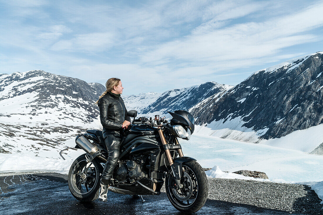 Frau auf Motorrad mit Blick auf Berge