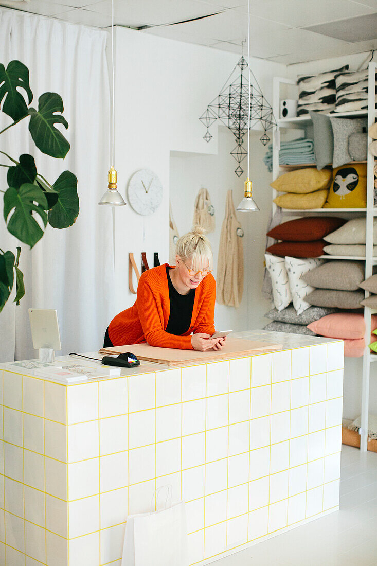 Woman in shop using cell phone