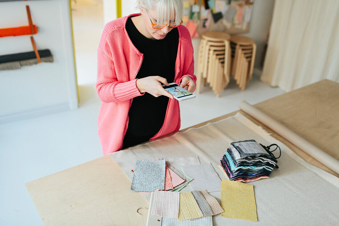 Woman taking photo of textiles in shop