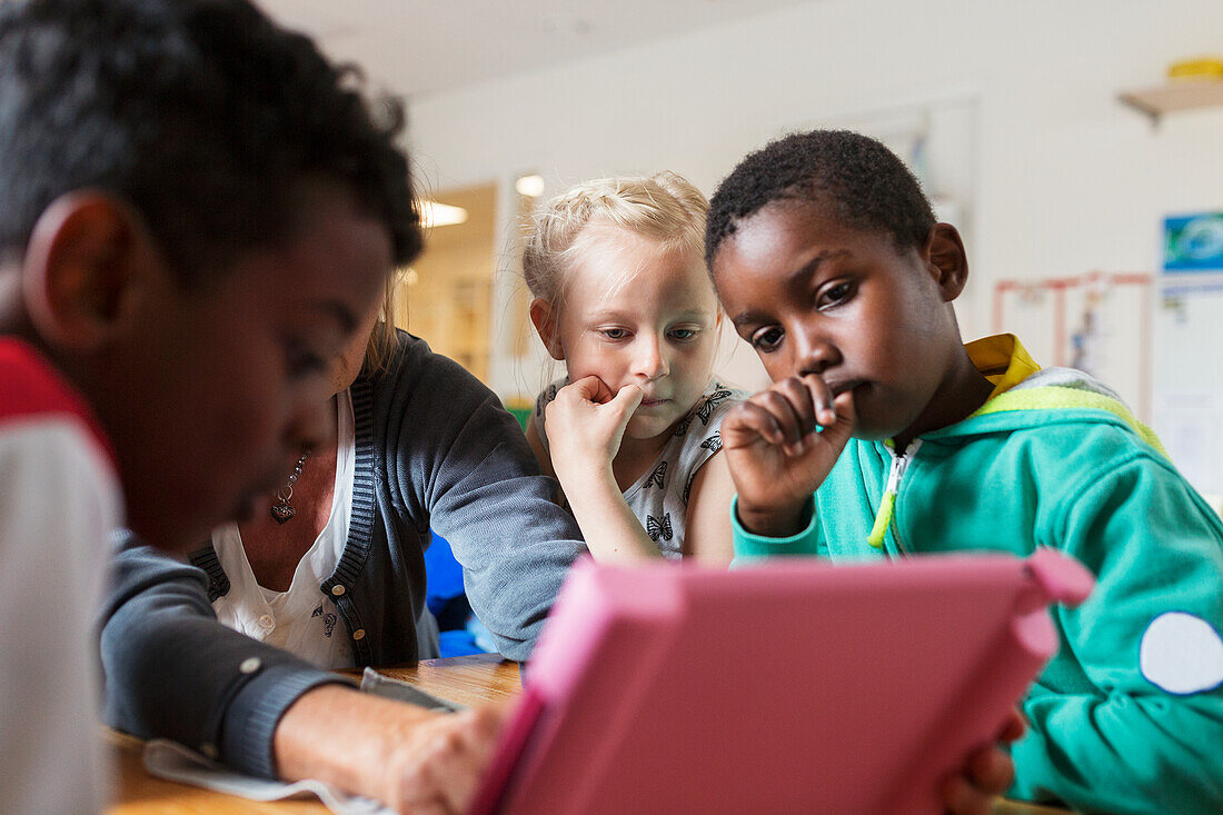 Kinder in der Schule mit digitalem Tablet