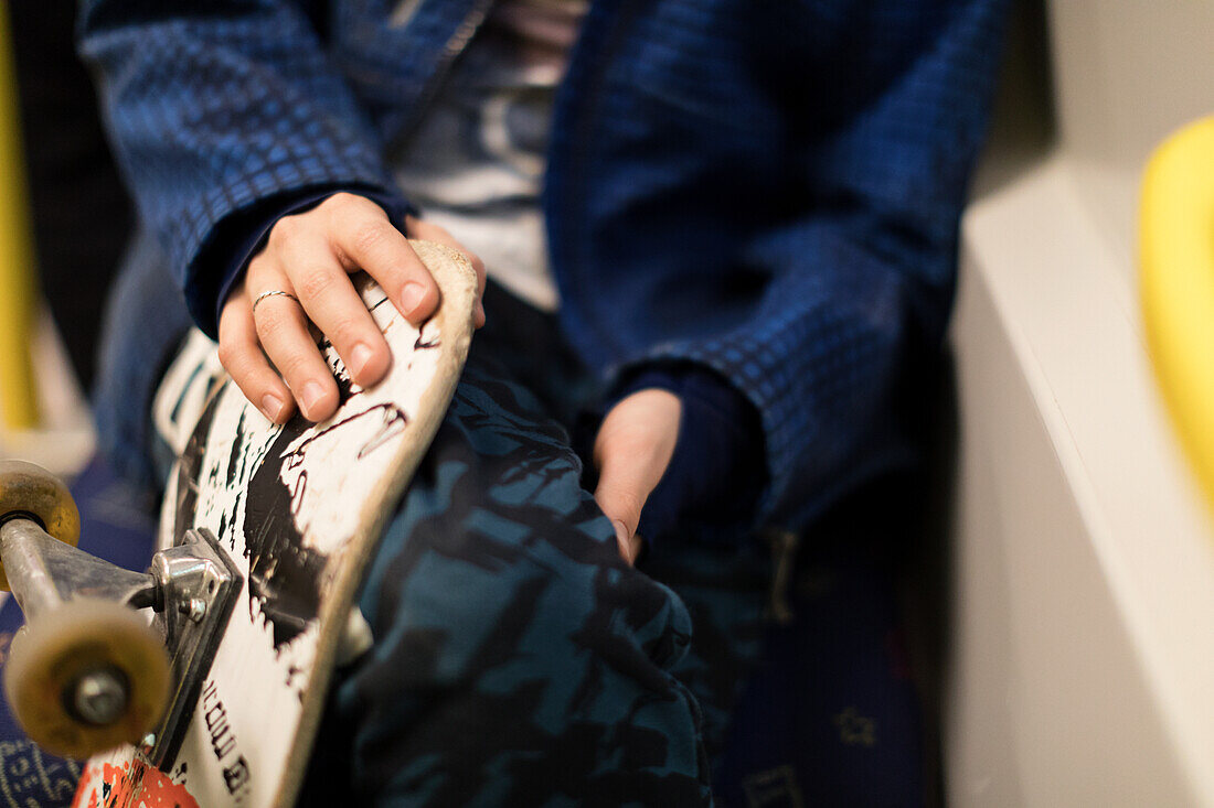 Boy holding skateboard, close-up