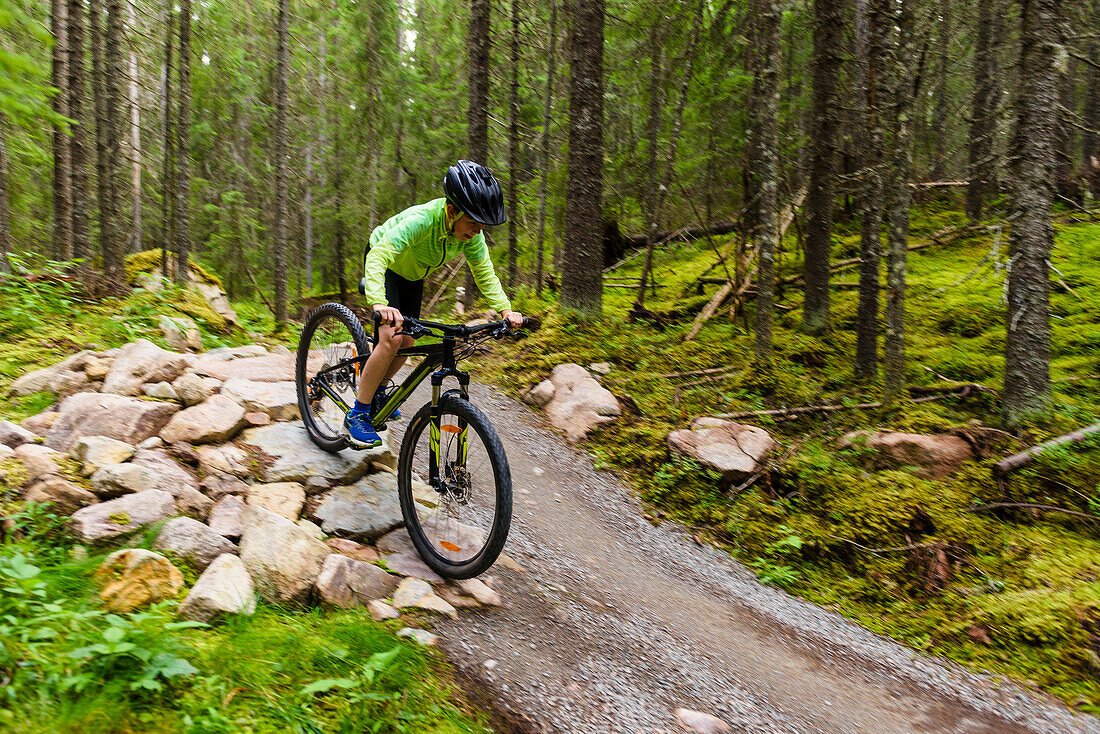 Boy cycling though forest