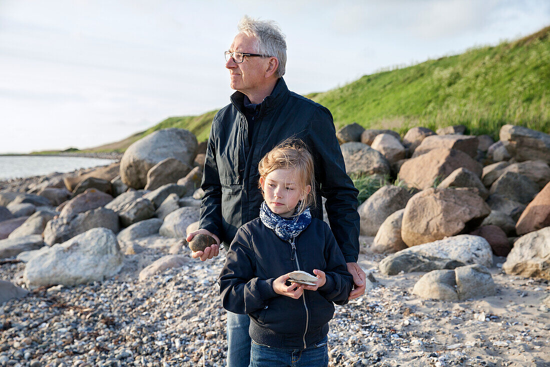 Großvater mit Enkelin am Strand