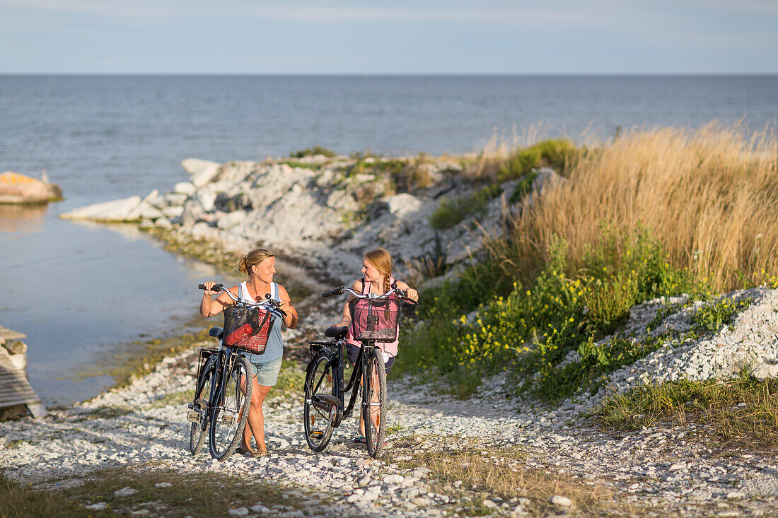 Young women cycling on sea coast