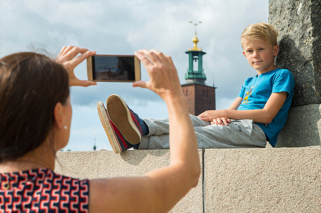 Mother taking picture of her son