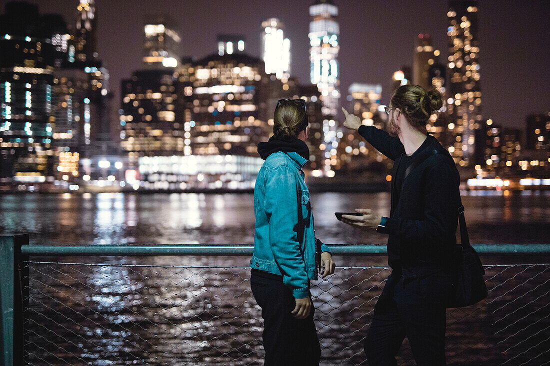 Couple looking at illuminated skyscrapers