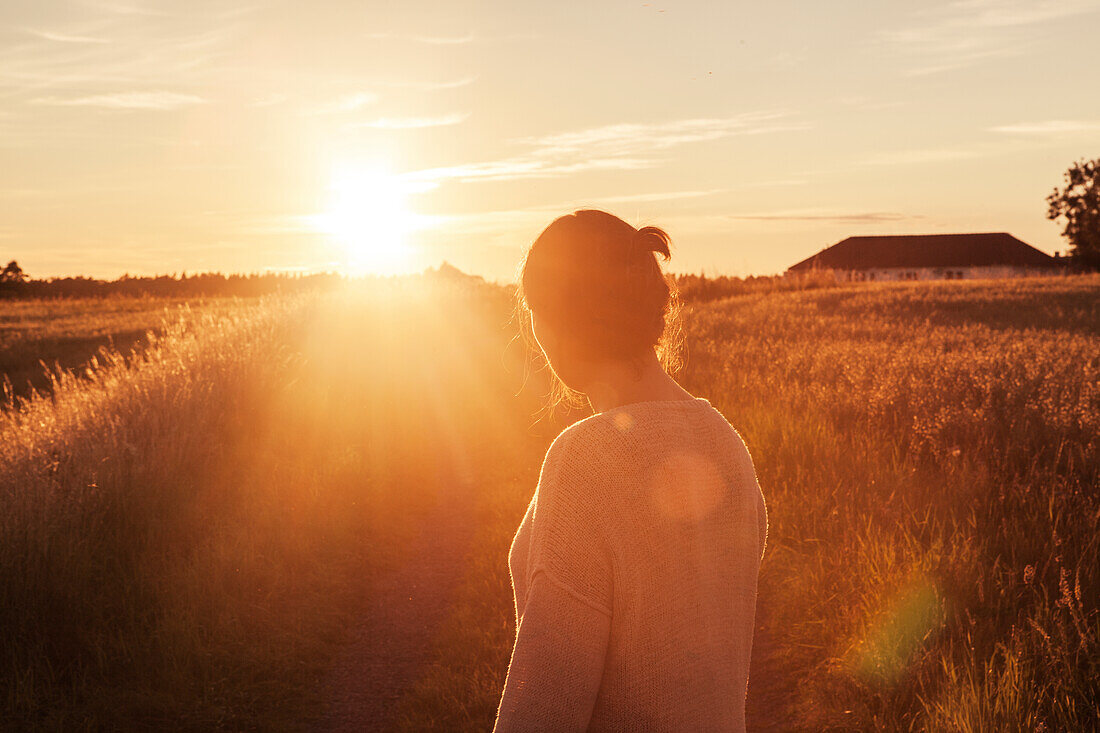 Frau schaut in den Sonnenuntergang