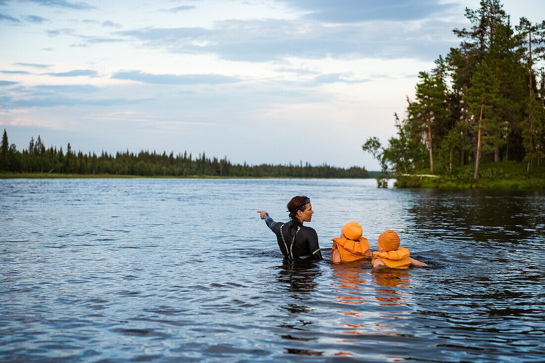 Mother with children swimming in lake