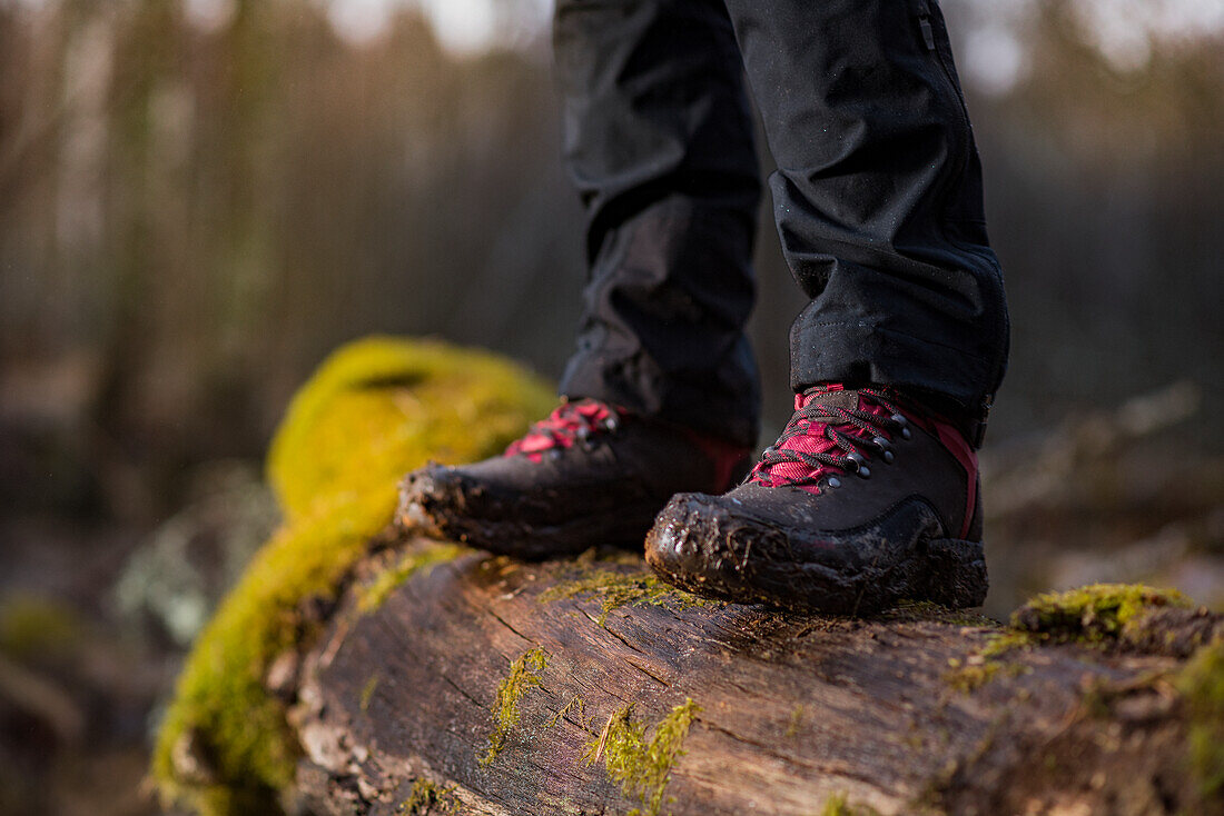 Person in hiking boots standing on log
