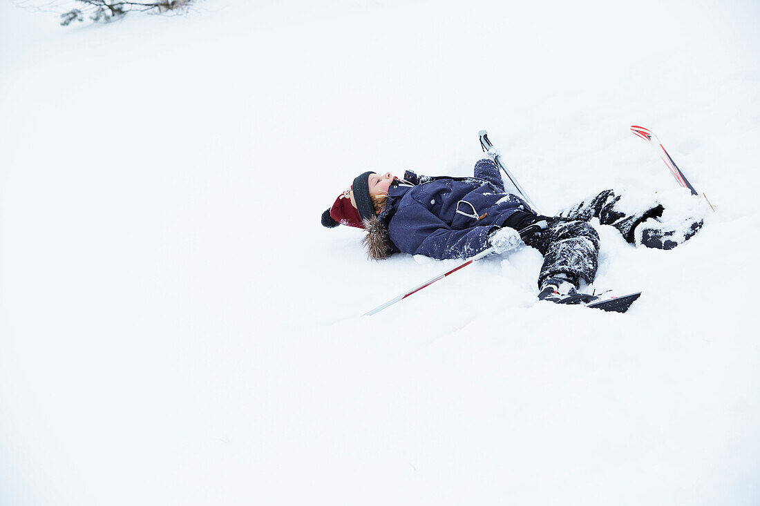 Mädchen liegend im Schnee