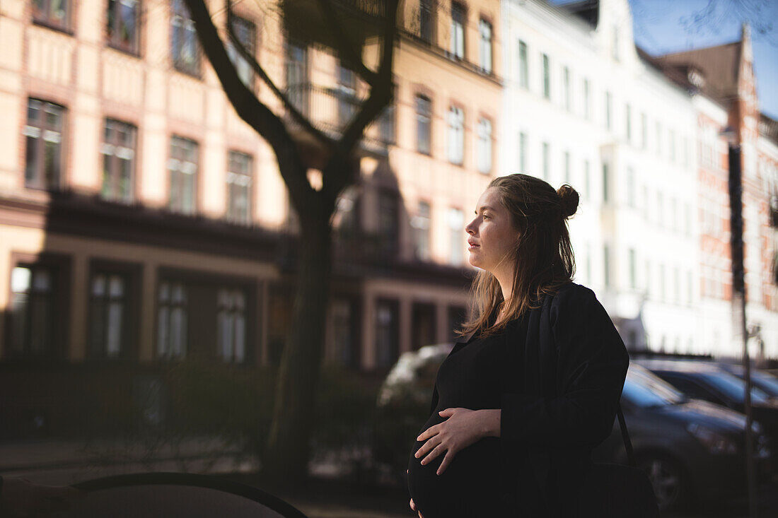 Pregnant woman standing on street