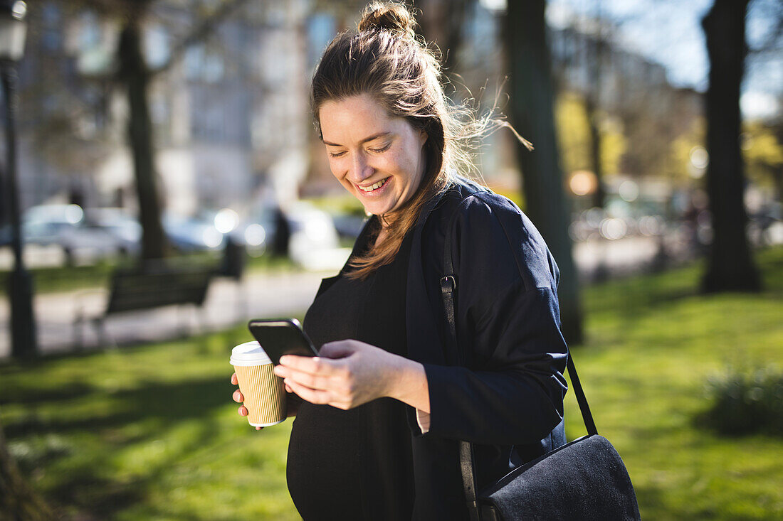 Frau mit Kaffee und Smartphone