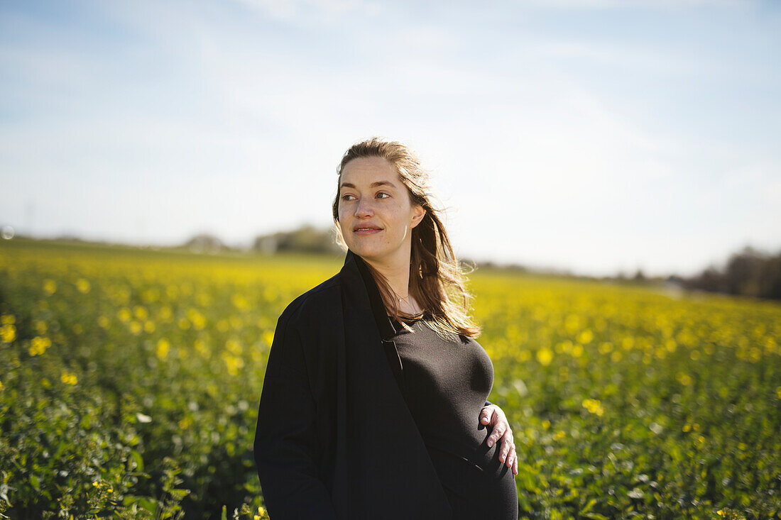 Pregnant woman contemplating in meadow