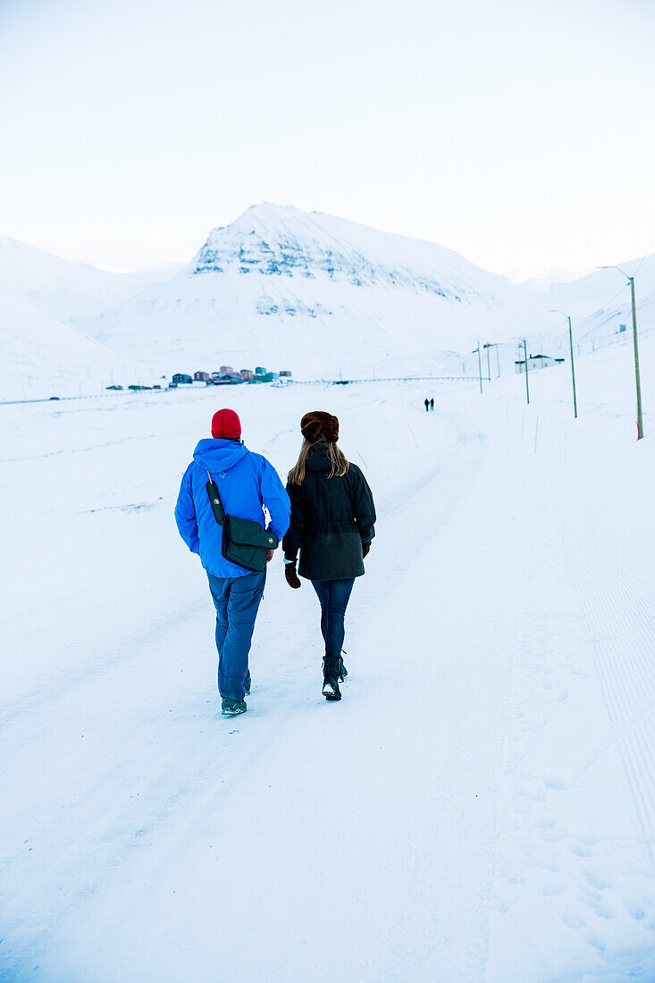 Couple walking on snow-covered road