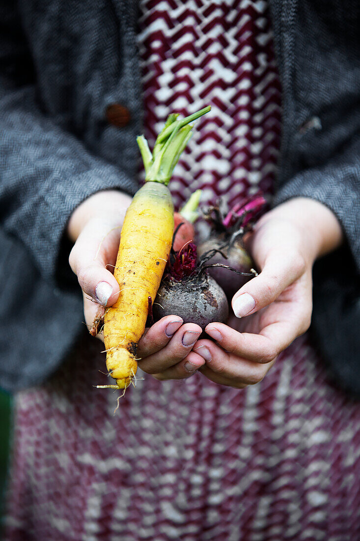 Girl holding carrot and beetroots