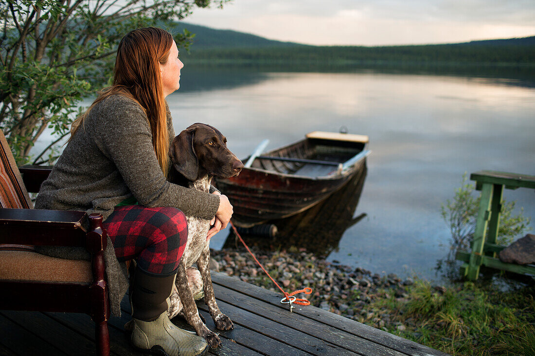 Woman with dog contemplating at seaside