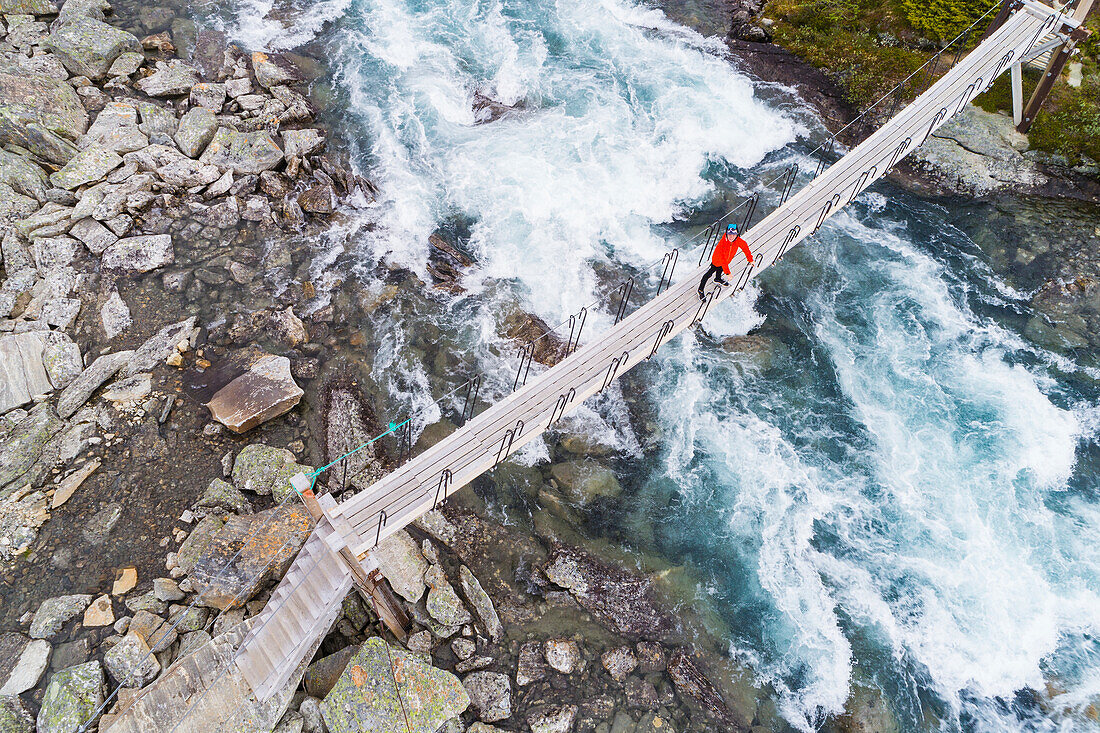 Person, die auf einem Steg über dem Fluss steht