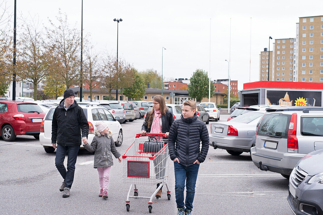 Familie auf dem Parkplatz eines Geschäfts