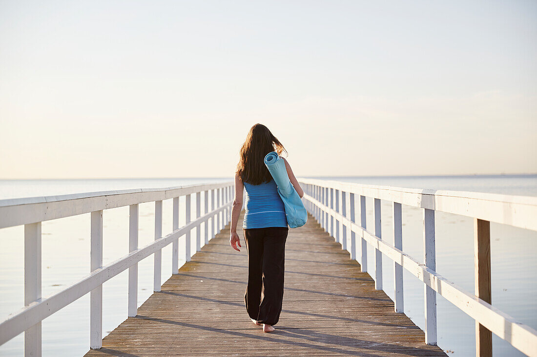 Woman walking on pier at seaside