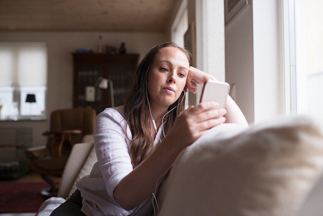 Young woman using phone at home