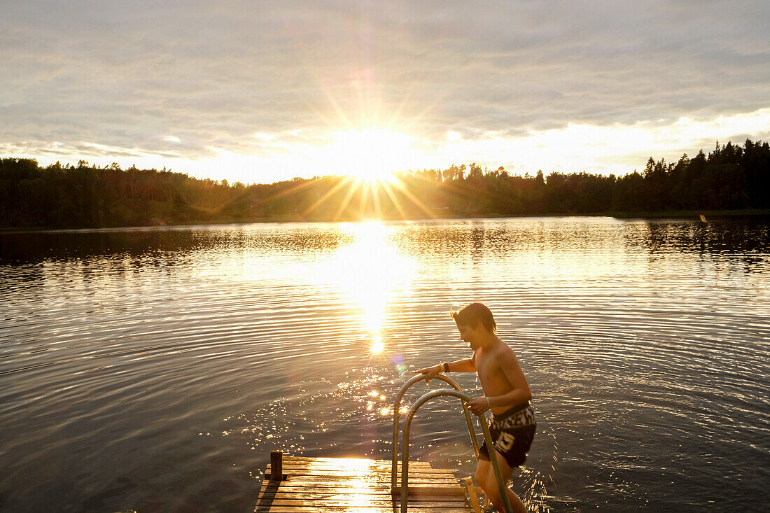 Boy on jetty at lake