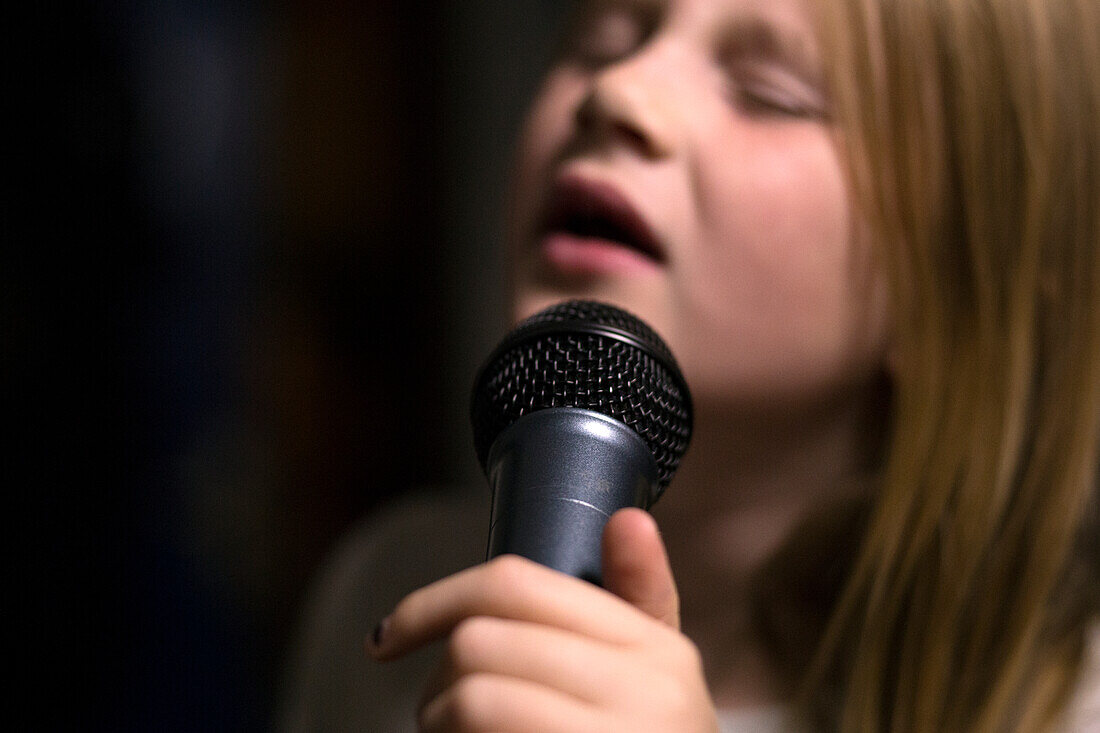 Girl holding microphone and singing
