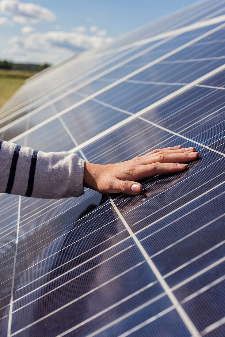 Hand touching solar panels