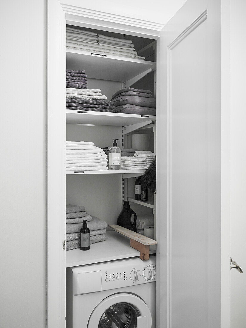 Cupboard with washing machine and towels