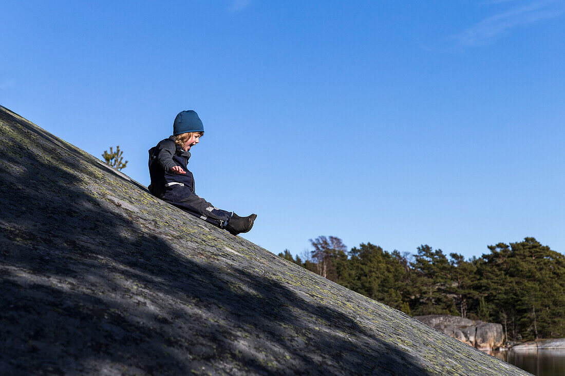 Boy sliding down hill