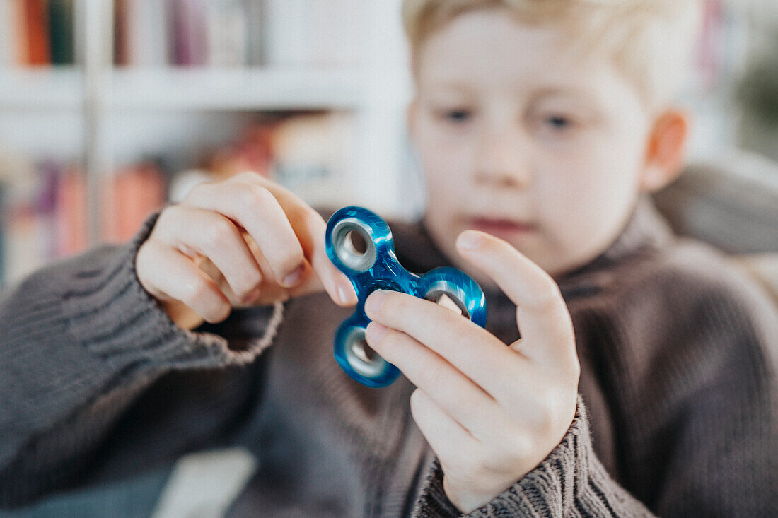 Junge spielt mit Fidget Spinner