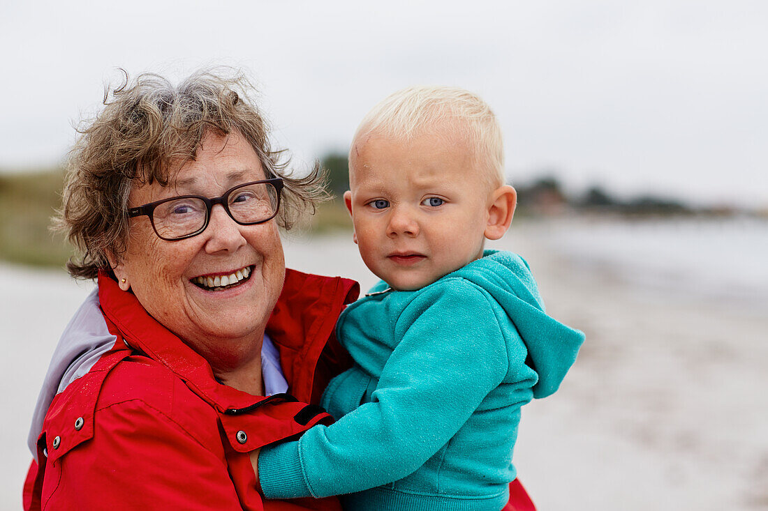 Portrait of grandmother carrying grandson