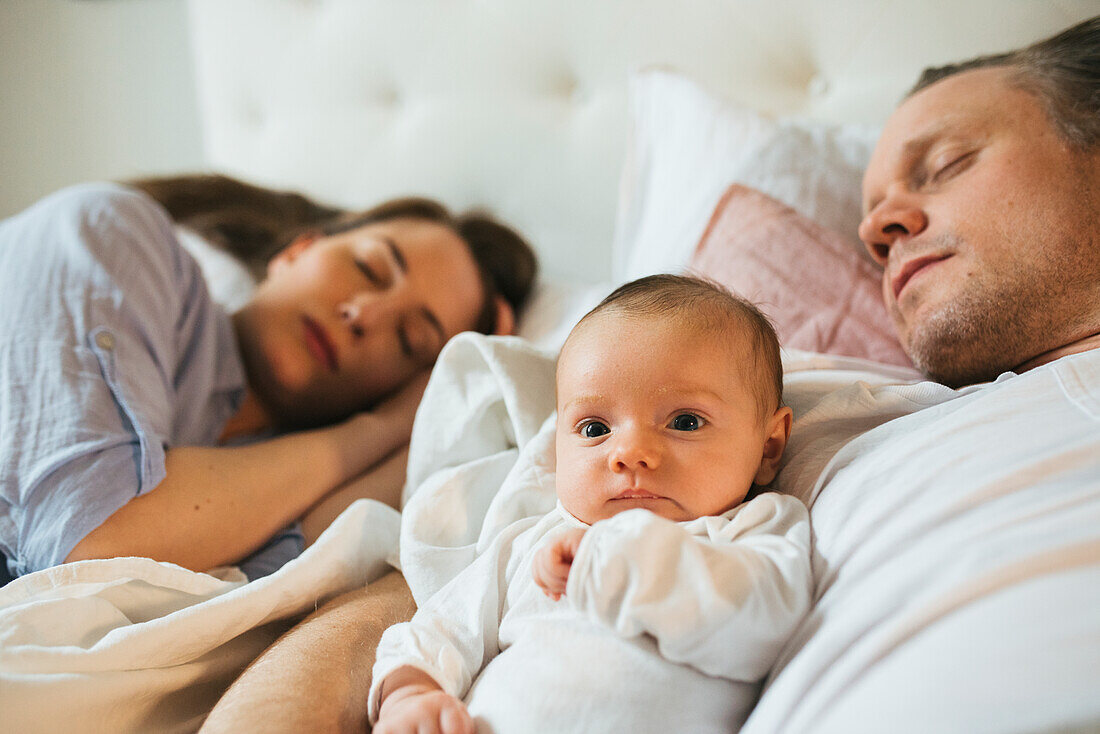 Eltern mit Baby im Bett