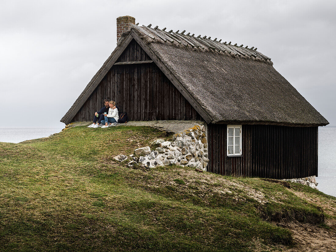 Couple resting near wooden house