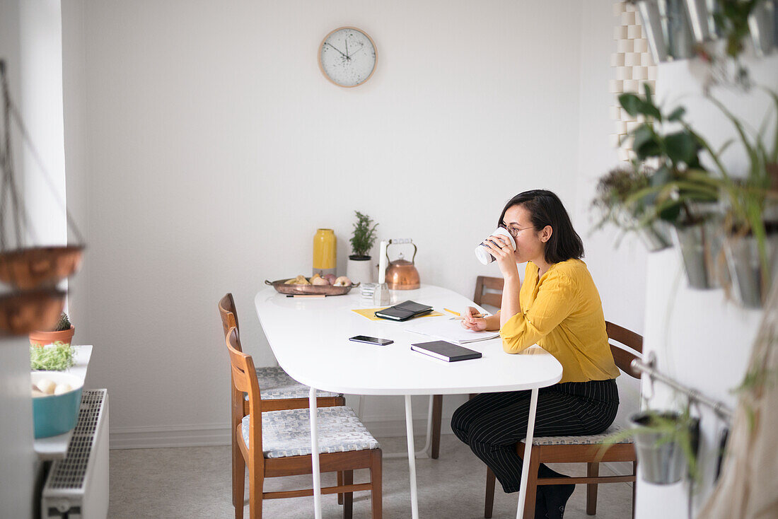 Woman drinking at dining table