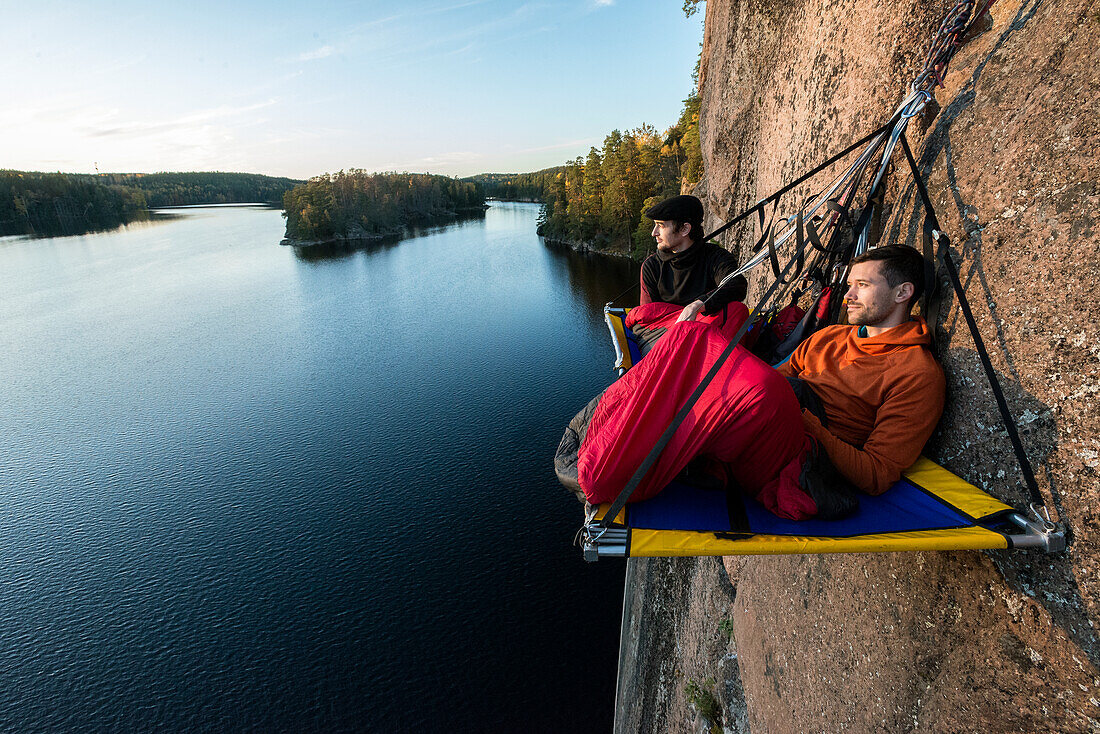 Zwei Wanderer ruhen sich in einer Portaledge aus