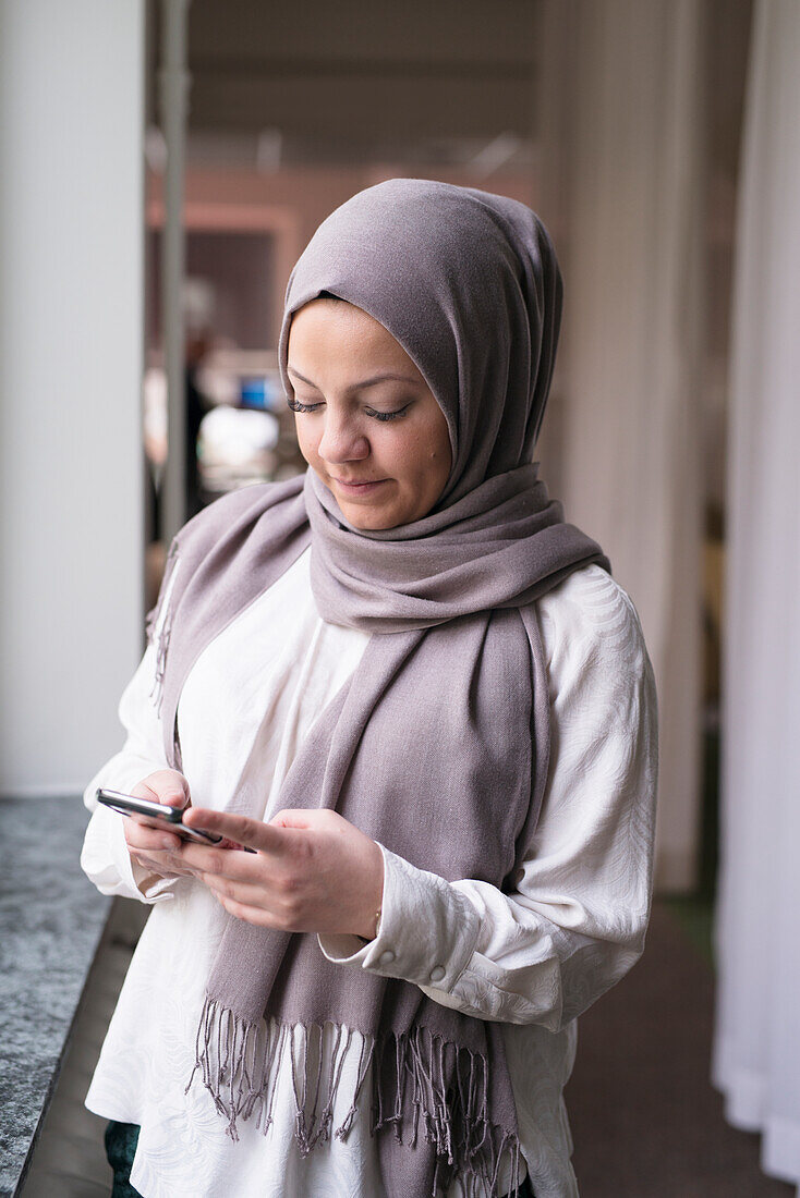 Young woman with smartphone in office