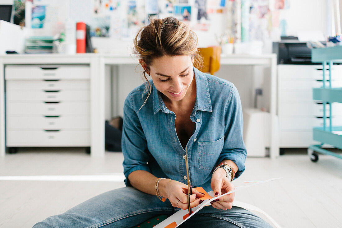 Young woman cutting out painted stripes