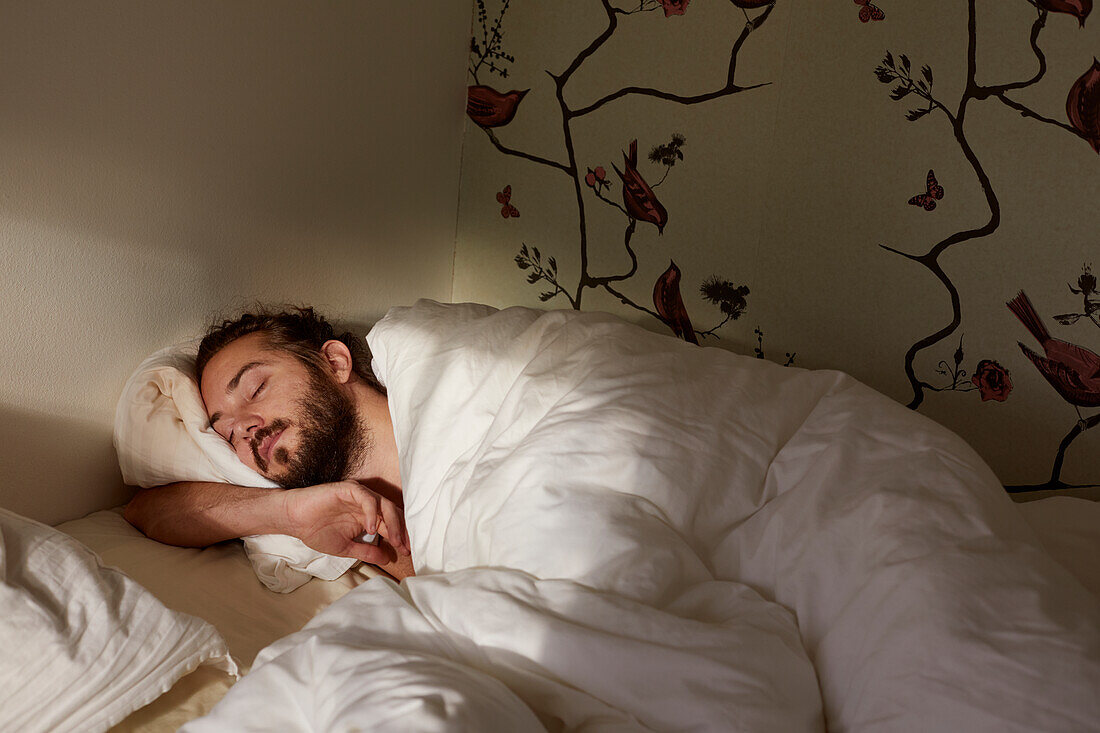 Mann schläft im Bett