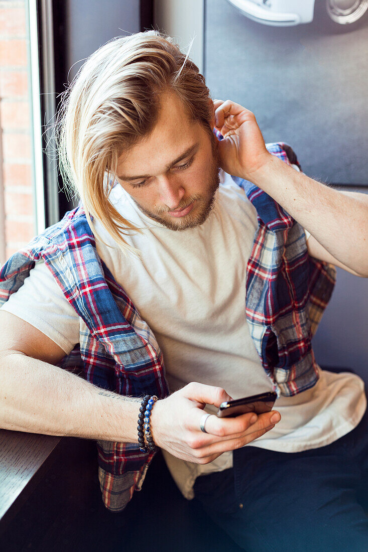 Junger Mann benutzt ein Mobiltelefon