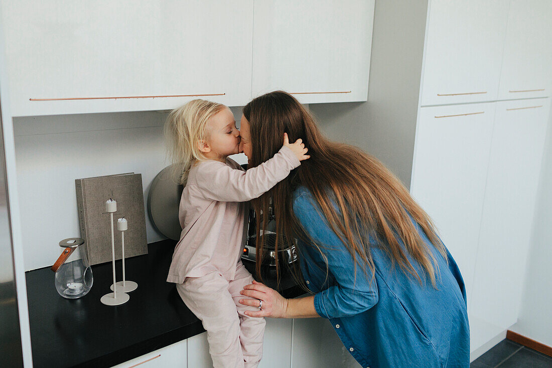 Mutter mit Tochter küssend