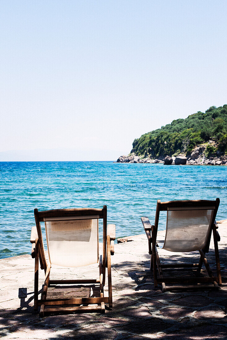 Sunchairs on sandy beach