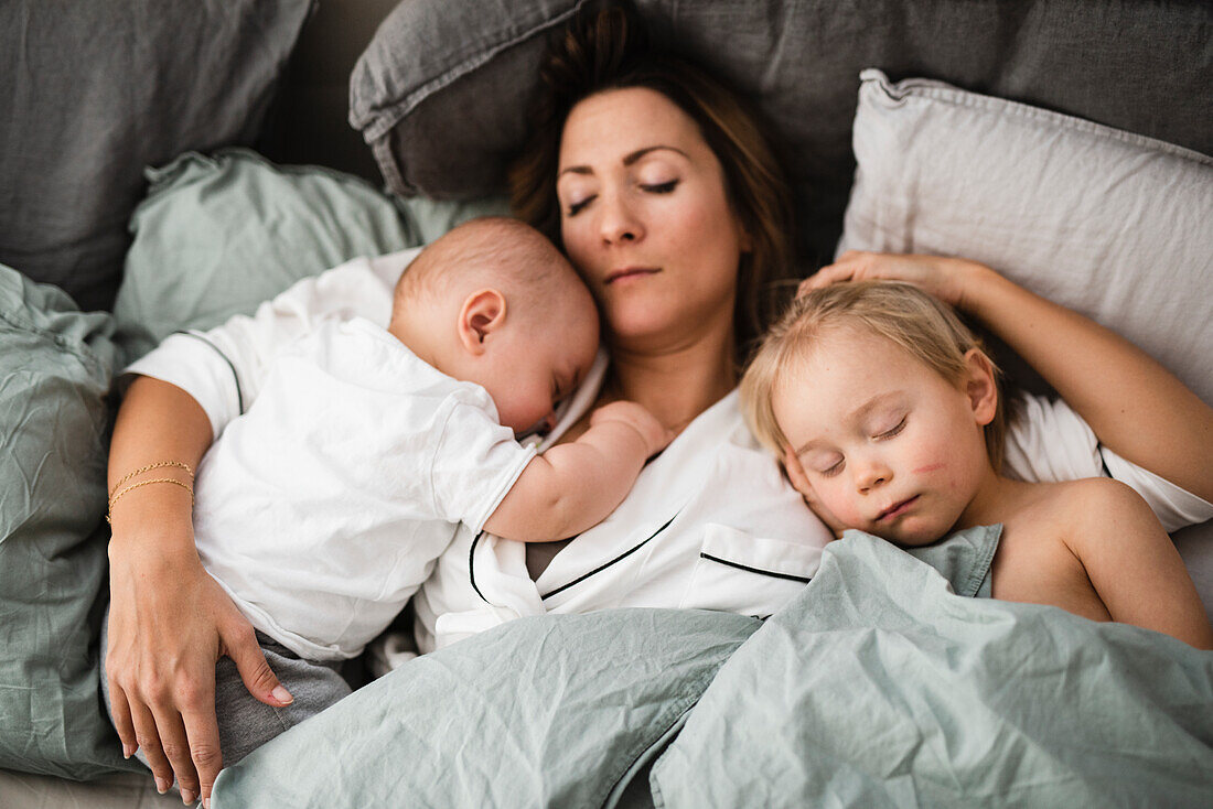 Mother lying in bed with sons
